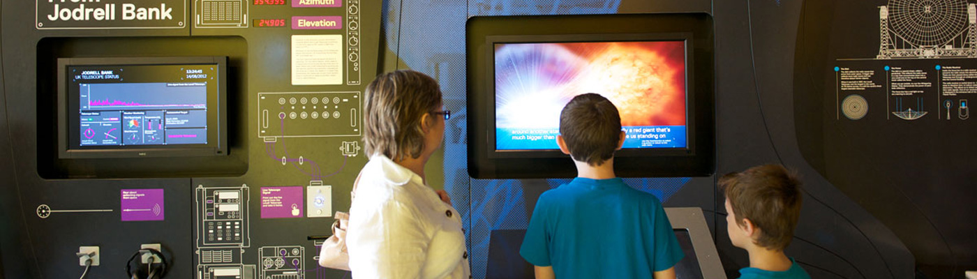 Grandmother and two grandchildren using interactive screen at Jodrell Bank Discovery Centre